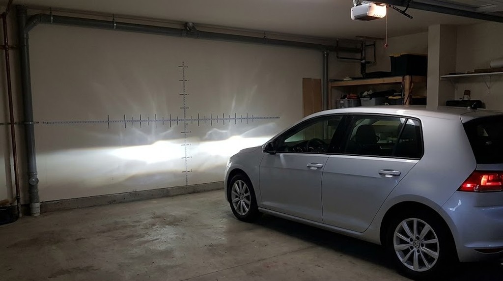 Автомобиль Golf в гараже с проекцией ближнего света на стене для регулировки фар